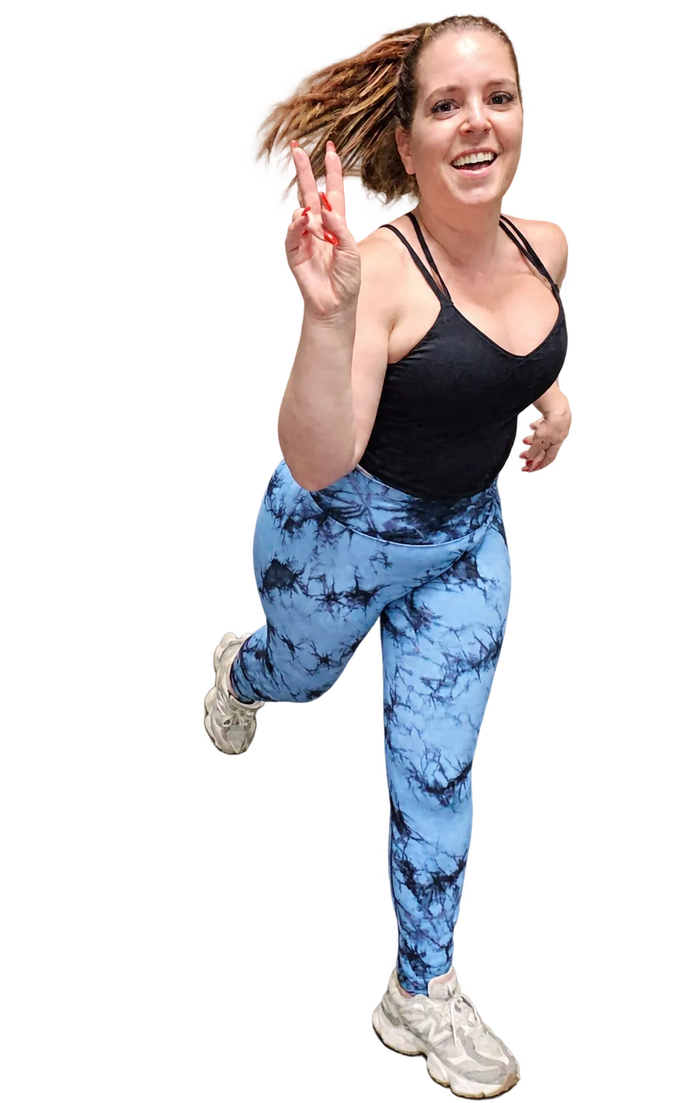 Femme sautant avec un débardeur noir et un legging bleu tie-dye